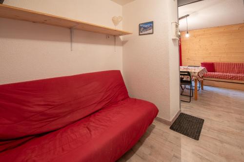 - un canapé rouge dans une chambre avec une table dans l'établissement appartement douillé, à Les Deux Alpes