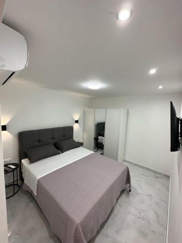 a bedroom with a bed in a white room at Apartmani Žaneta in Kaštela