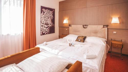 a bedroom with a large bed with white sheets at Malkia Penzion in Orechová Potôň
