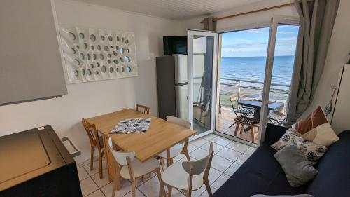 - un salon avec une table et une vue sur l'océan dans l'établissement Appartement vue mer - accès direct à la plage - 4 à 5 personnes, à Saint-Hilaire-de-Riez