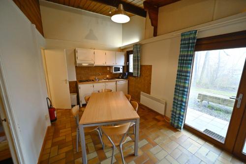 a kitchen with a table and chairs in a room at Village de Vacances d'Oignies in Oignies-en-Thierache