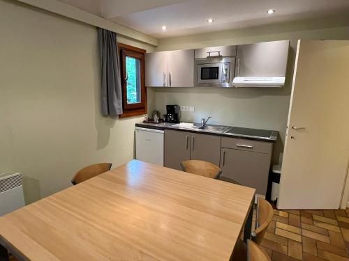 a kitchen with a wooden table and a counter top at Village de Vacances d'Oignies in Oignies-en-Thierache