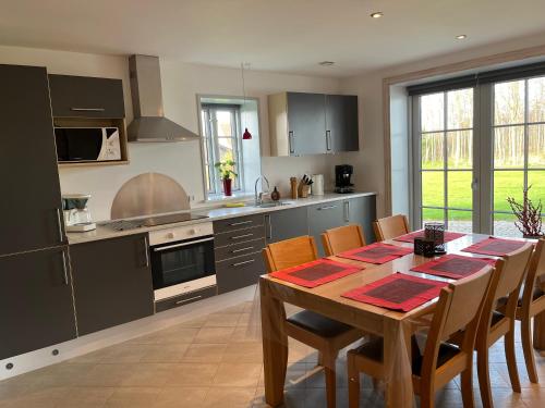 a kitchen with a wooden table and a dining room at Ferielejlighed in Nørre Åby