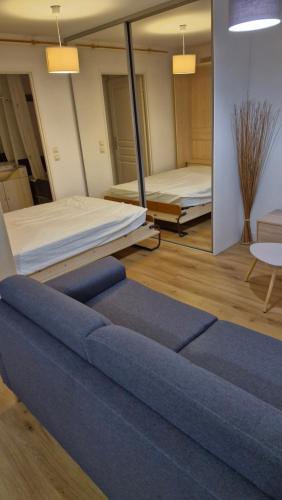 - un salon avec un canapé bleu et 2 lits dans l'établissement Concarneau - Beau studio chaleureux avec jardin, à Concarneau