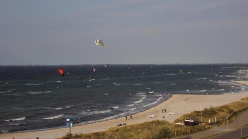 a group of people on a beach flying a kite at Turm-Penthouse Heiligenhafen in Heiligenhafen