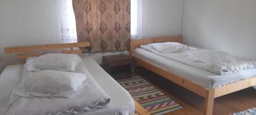 two twin beds in a room with a rug at Cabana Mihaela in Gîrda de Sus