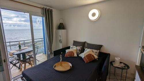 Il comprend un salon avec un lit et un balcon donnant sur l'océan. dans l'établissement Appartement vue mer - accès direct à la plage - 4 à 5 personnes, à Saint-Hilaire-de-Riez
