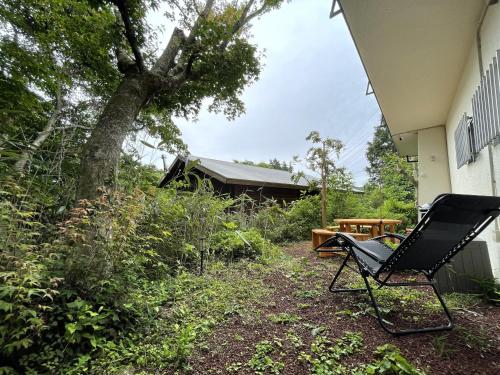 a black chair sitting next to a house at GranGiorno HAKONE Kowakidani in Ashinoyu