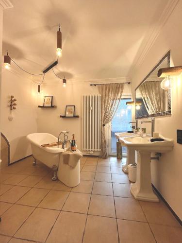 a bathroom with two sinks and a tub and a mirror at Oase am Pferdemarkt - exklusives Wohnen im Herzen Ostfrieslands - Luxus und Wohlfühlatmosphäre in Aurich