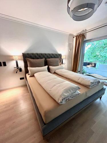 two beds in a bedroom with a large window at Oase am Pferdemarkt - exklusives Wohnen im Herzen Ostfrieslands - Luxus und Wohlfühlatmosphäre in Aurich