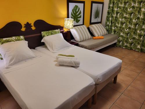 2 aparte bedden in een kamer met een bank bij Au beau village studio vue nature in Sainte-Luce