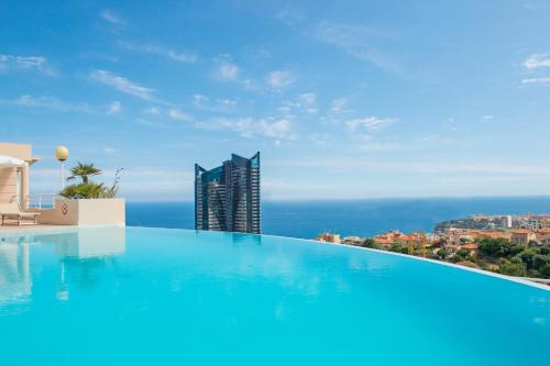 a swimming pool with a view of a building at BEAUSEJOUR - Splendide 2 pièces - Piscine - Parking - Vue mer in Beausoleil