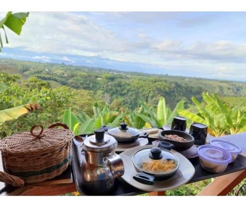 a table with dishes of food on it with a view at Cabañas la Miranda in Filandia