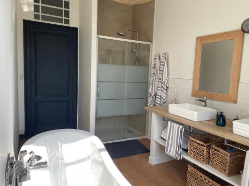 une salle de bain avec une baignoire, un lavabo et un miroir dans l'établissement Demeure de charme proche Saint-Emilion - Piscine et Parc, à Flaujagues