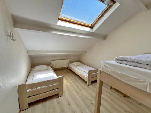 a small room with two beds and a skylight at La Recreation in Somme-Leuze