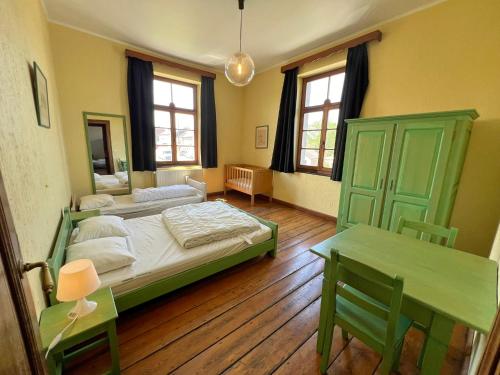 a bedroom with a bed and a table and a mirror at La Recreation in Somme-Leuze