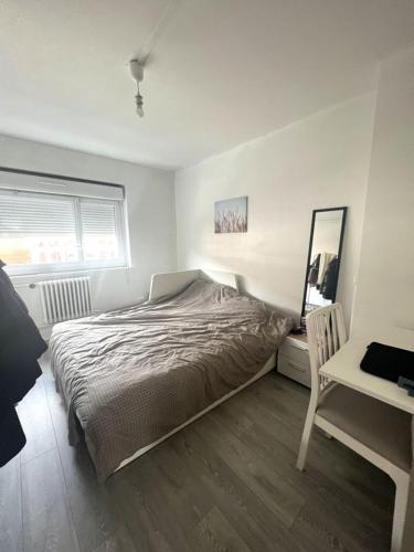 une chambre avec un lit, un bureau et un miroir dans l'établissement Appartement COSY, à Neuilly-sur-Seine
