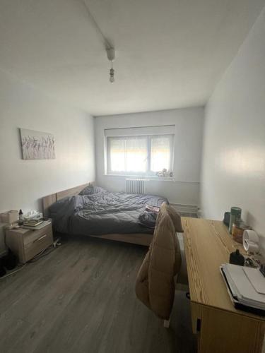 une chambre avec un lit et un bureau avec un bureau dans l'établissement Appartement COSY, à Neuilly-sur-Seine