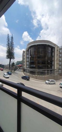 a building with a parking lot with cars in front of it at JCGA Apartments at Megatower Residences IV - Near SM & Session Rd in Baguio