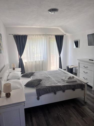 a bedroom with a large white bed with a window at CASA ALEXANDRA in Galeş