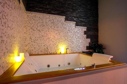 a large bath tub in a room with a brick wall at Villa Bianca Hotel & Spa in San Salvo