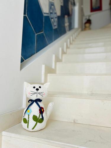a stuffed cat sitting on a ledge next to stairs at B&B Casa di Emma in Porto Cesareo
