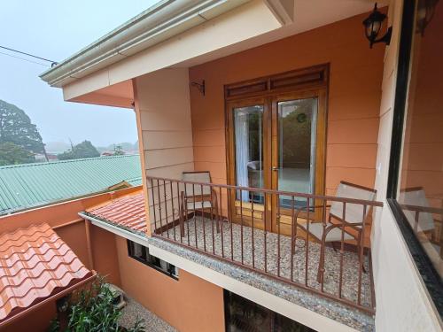 a balcony of a house with two chairs at Mi Casa Su Casa Monteverde in Monteverde Costa Rica