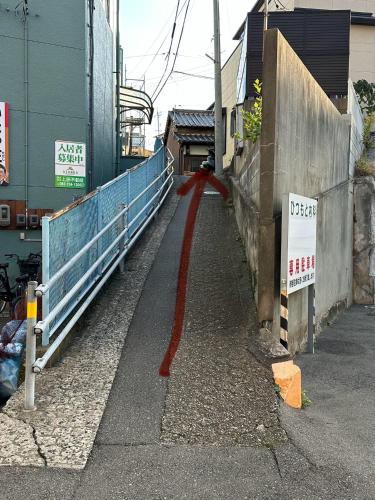 a red line on a sidewalk next to a building at Guest House" Ro" takezaki in Amanogōchō
