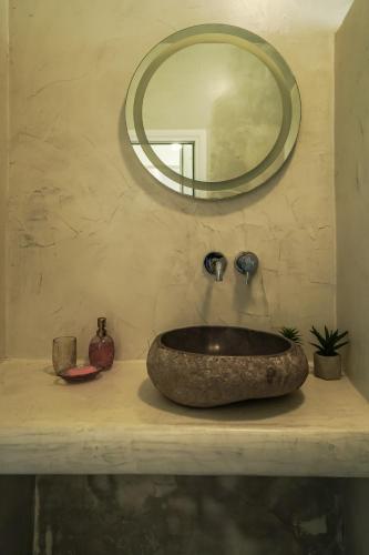 a bathroom with a stone sink and a mirror at Dream Santo Villa in Vóthon