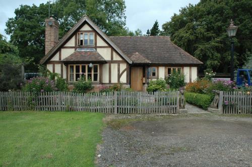 una pequeña casa con una valla blanca en Stay with Robin, en Dorking