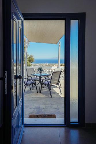 an open door to a patio with a table and chairs at Dream Santo Villa in Vóthon