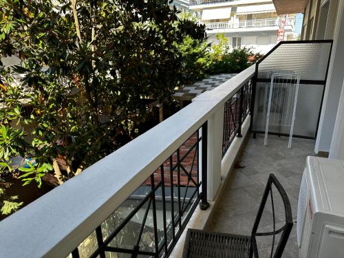 a balcony with a railing and two chairs and trees at Apartments Villa Effie in Paralia Katerinis