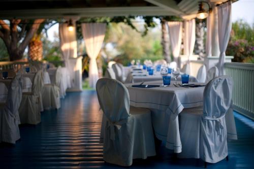 un tavolo bianco con sedie e bicchieri da vino sopra di Hotel Mediterraneo a Santa Maria Navarrese