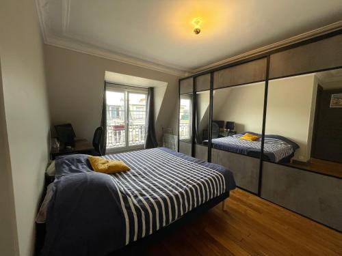 une chambre avec deux lits et un grand miroir dans l'établissement La casa du 15e, Tour Eiffel view, à Paris