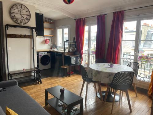 - un salon avec une table et une horloge murale dans l'établissement La casa du 15e, Tour Eiffel view, à Paris