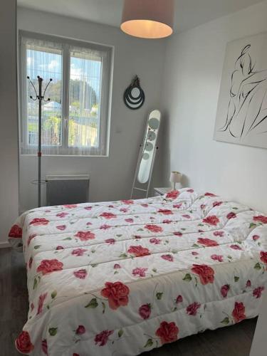 une chambre avec un lit avec des fleurs rouges dessus dans l'établissement Maison proche du bord de mer, à Riantec