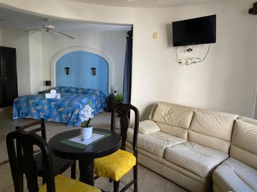 a living room with a couch and a bed and a table at Hotel Castillo Del Mar - 5 Th Ave in Playa del Carmen