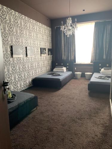 a bedroom with two beds and a chandelier at Hostel Terre in Fellbach