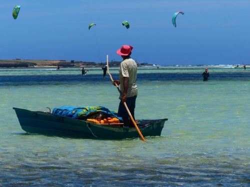 a man is standing in a boat in the water at Varatraza Wind Riders in Diego Suarez