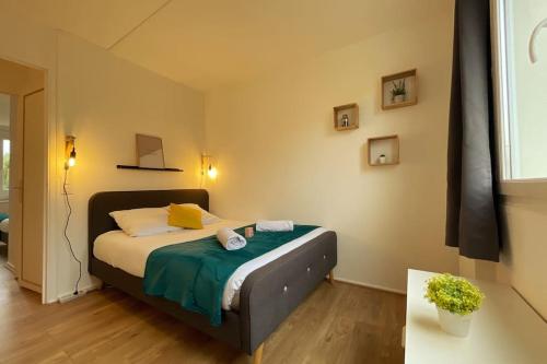 a bedroom with a bed with a green blanket at Rouen Port de plaisance et MIN - Appart lumineux in Rouen
