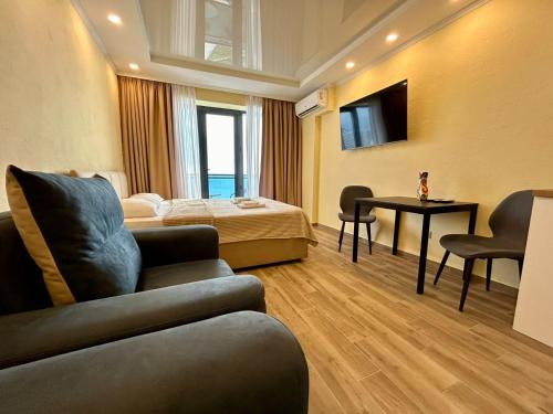 a hotel room with a bed and a couch at Real Beach Tower in Batumi