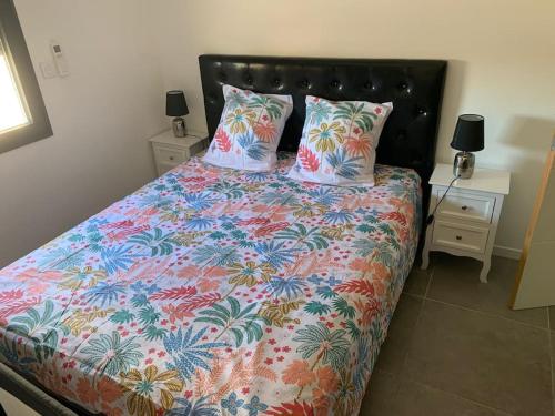 - un lit avec une couette colorée et 2 oreillers dans l'établissement l étoile de mer logement 4, à Sainte-Marie-la-Mer