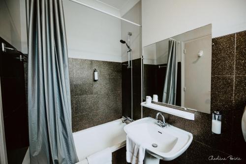 a bathroom with a sink and a shower at Grand Hotel Des Bains & Villas des Bains in Vals-les-Bains
