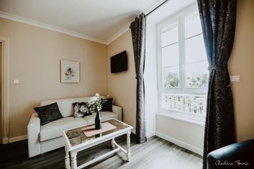 a living room with a couch and a window at Grand Hotel Des Bains & Villas des Bains in Vals-les-Bains