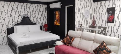 a bedroom with a white bed and a couch at Jack Kandi Grosvenor Square in Angeles