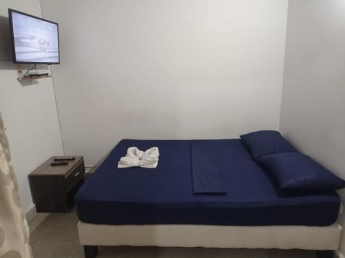 a bedroom with a blue bed with a white bow on it at Yellow House Hostel in Medellín