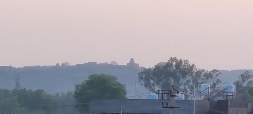 a person standing on top of a building on a hill at Cave View Homestay in Badami
