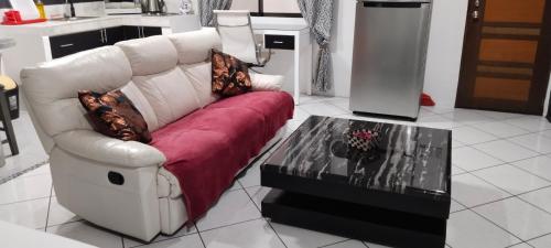 a living room with a white couch and a table at Jack Kandi Grosvenor Square in Angeles