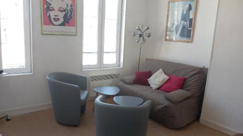 un salon avec un canapé et une chaise dans l'établissement deauville morny plein centre, à Deauville