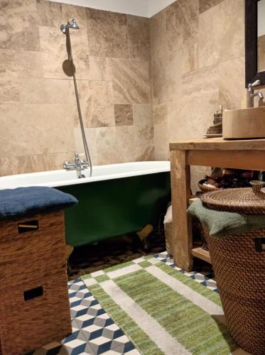 une salle de bain avec une baignoire verte et une table dans l'établissement T3 Au cœur de Marseille, à Marseille